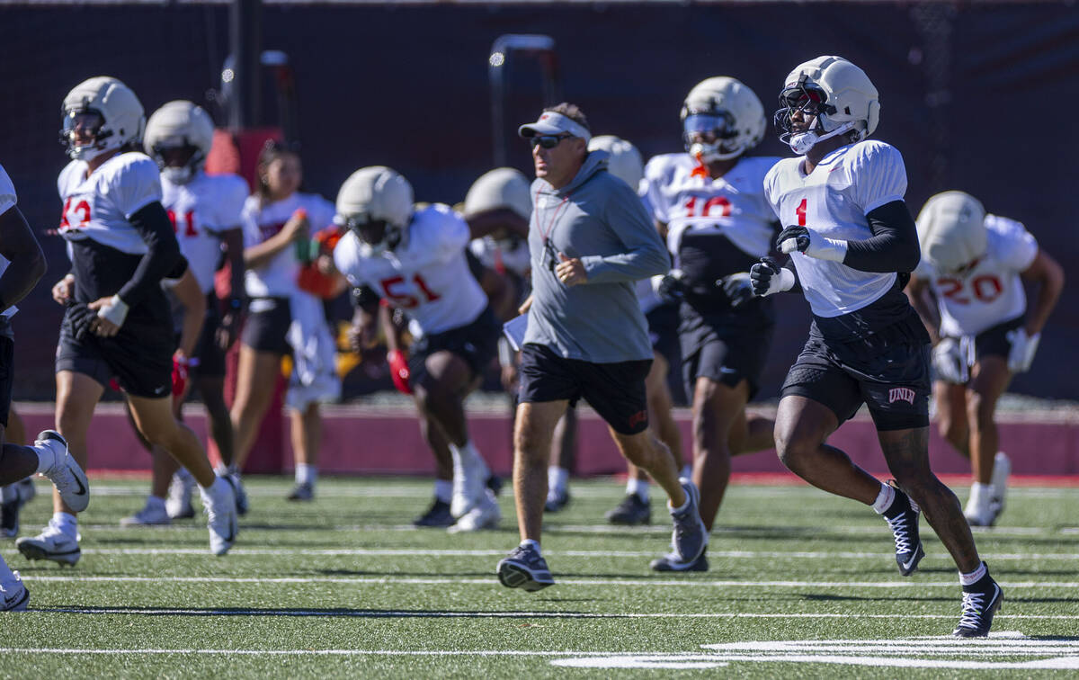 UNLV outside linebacker Chief Borders runs with head coach Dan Mullen and others to a new drill ...