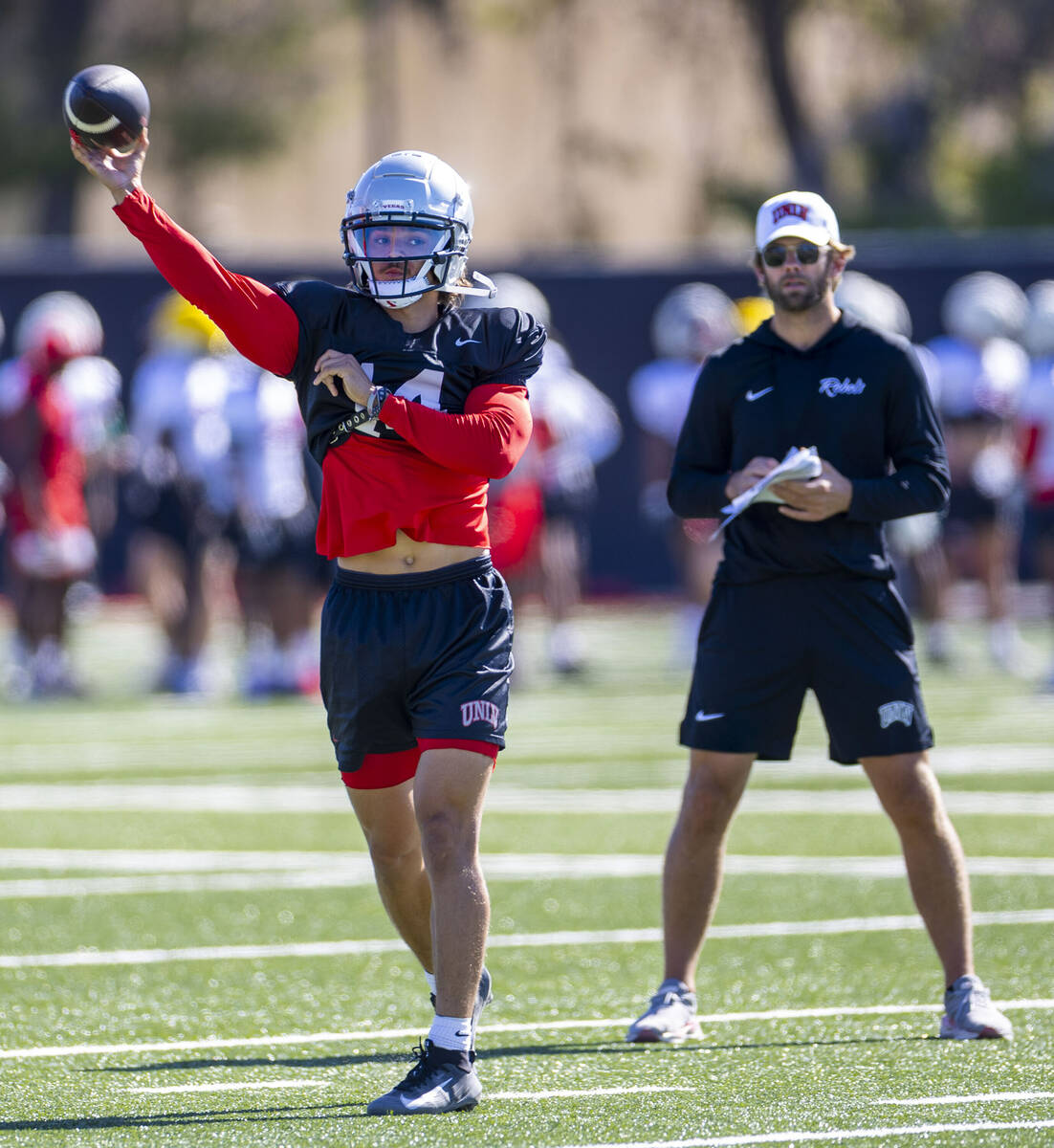 UNLV quarterback Gael Ochoa (14) gets off a pass as offensive coordinator and quarterbacks coa ...