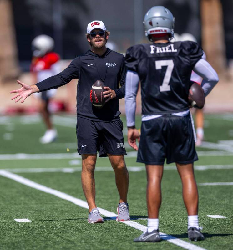 UNLV offensive coordinator and quarterbacks coach Corey Dennis works on technique with quarterb ...