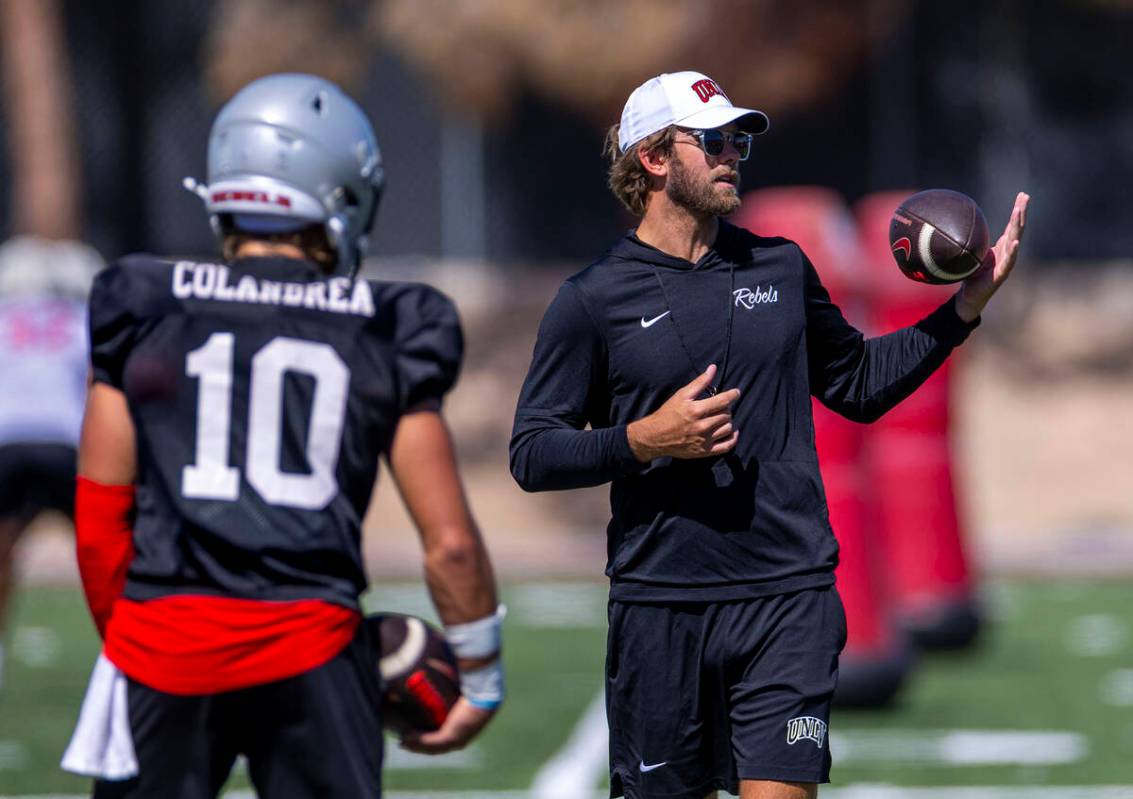 UNLV offensive coordinator and quarterbacks coach Corey Dennis talks technique with quarterback ...