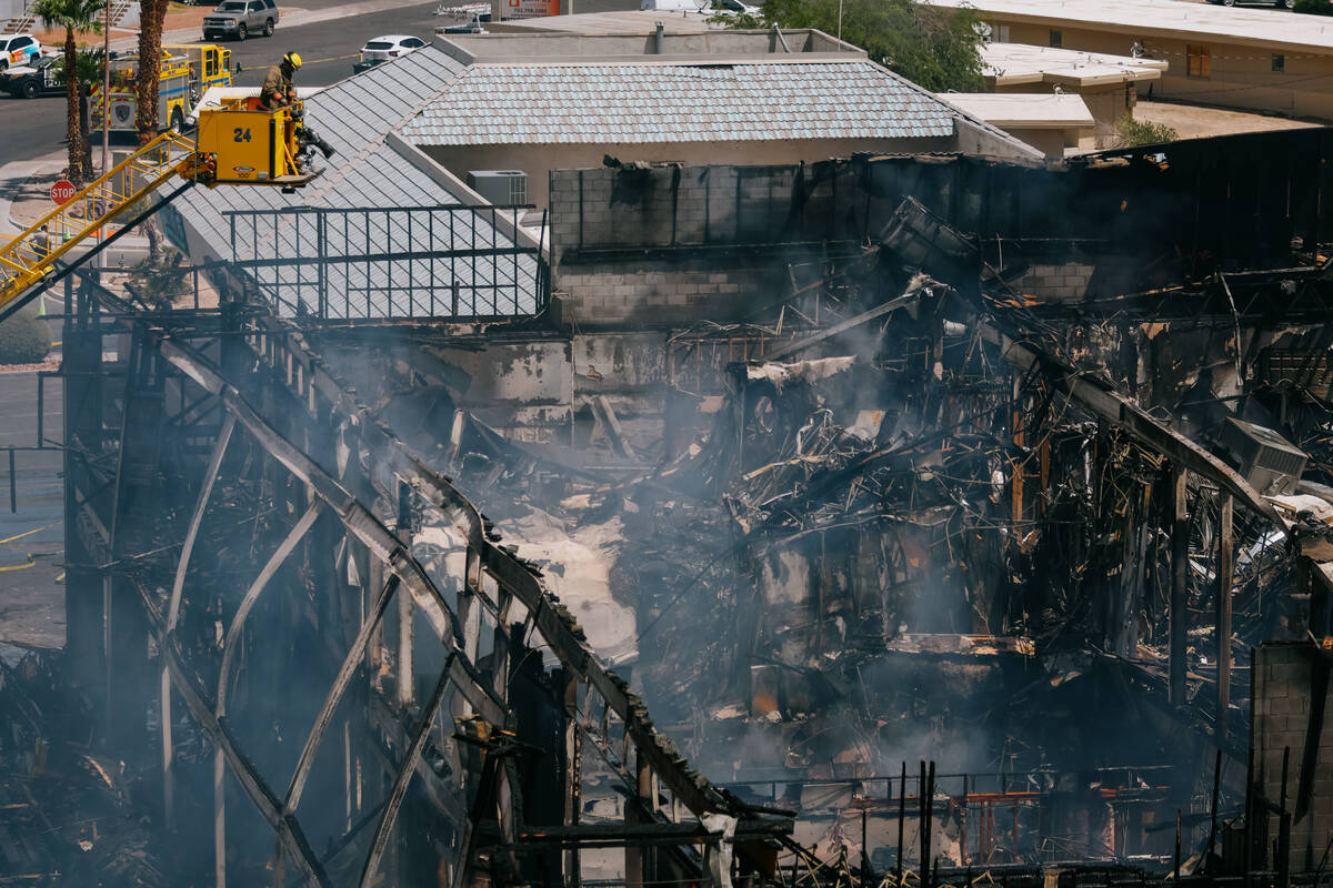 Firefighters douse the still-smoking building that once housed the post office on Maryland Pkwy ...
