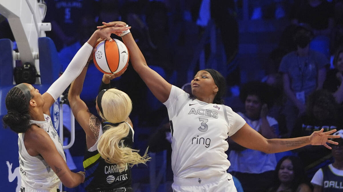 Dallas Wings guard DiJonai Carrington is stopped by Las Vegas Aces forward NaLyssa Smith (3) an ...