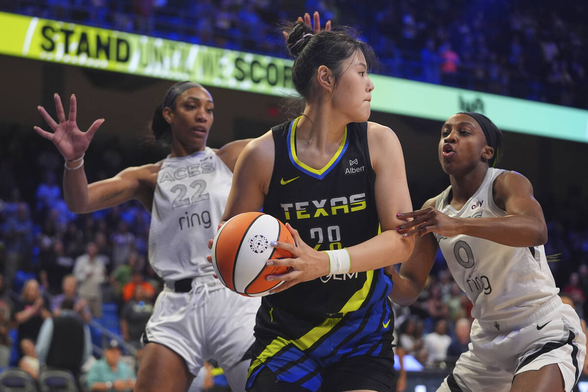 Dallas Wings center Li Yueru (28) keeps the ball from Las Vegas Aces guard Jackie Young (0) and ...
