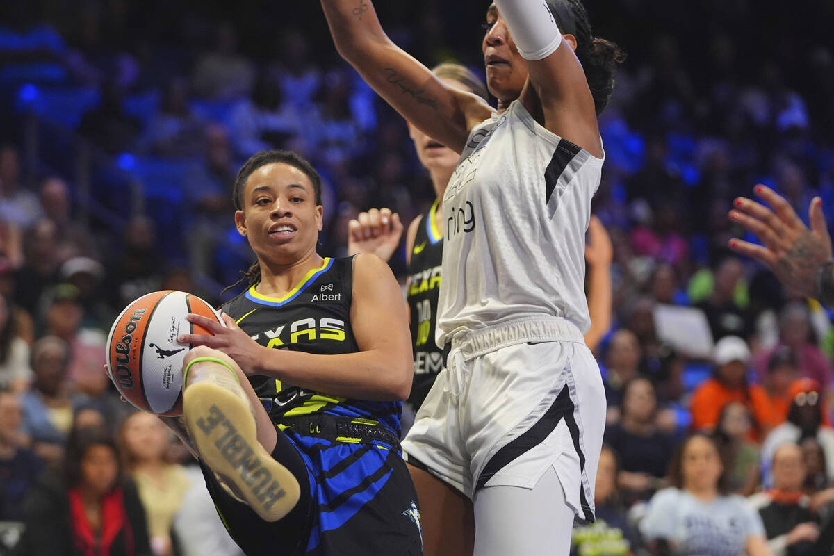 Dallas Wings guard JJ Quinerly, left, gets a rebound against Las Vegas Aces center A'ja Wilson, ...