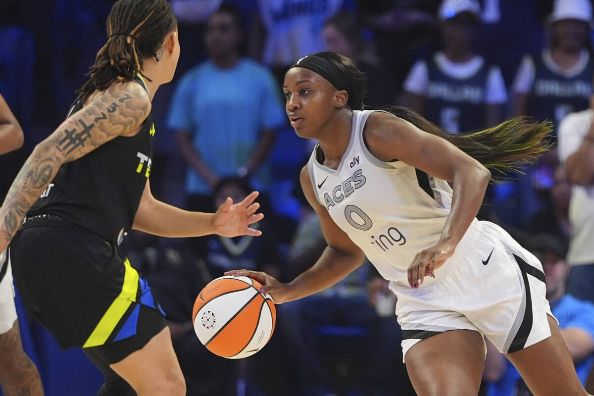 Las Vegas Aces guard Jackie Young (0) drives against Dallas Wings guard Aziaha James, left, dur ...