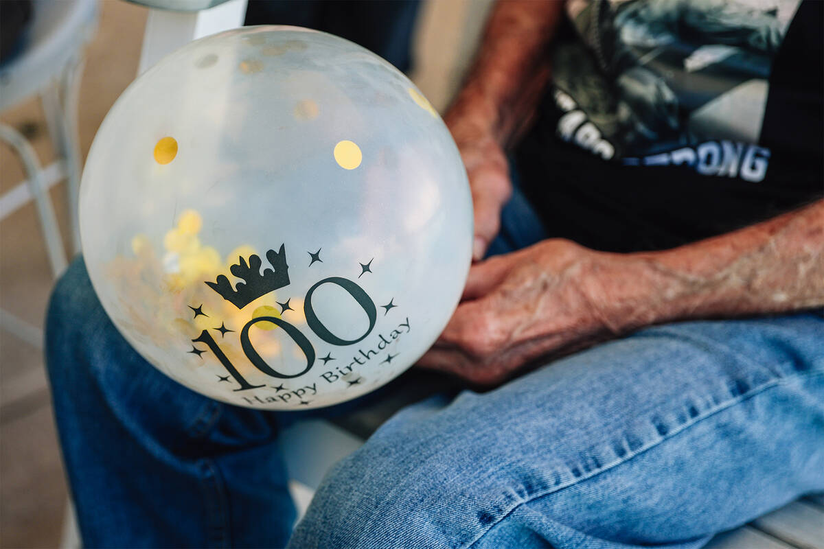 Robert “Bob” Lee Trent, who is turning 100 on Monday, holds a balloon at his birt ...