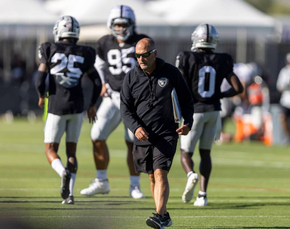 Raiders special teams coordinator Tom McMahon walks the field with his playbook during the team ...