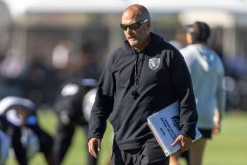 Raiders special teams coordinator Tom McMahon walks the field with his playbook during the team ...