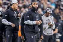 Raiders defensive tackle Christian Wilkins, right, watches the team play from the sideline duri ...