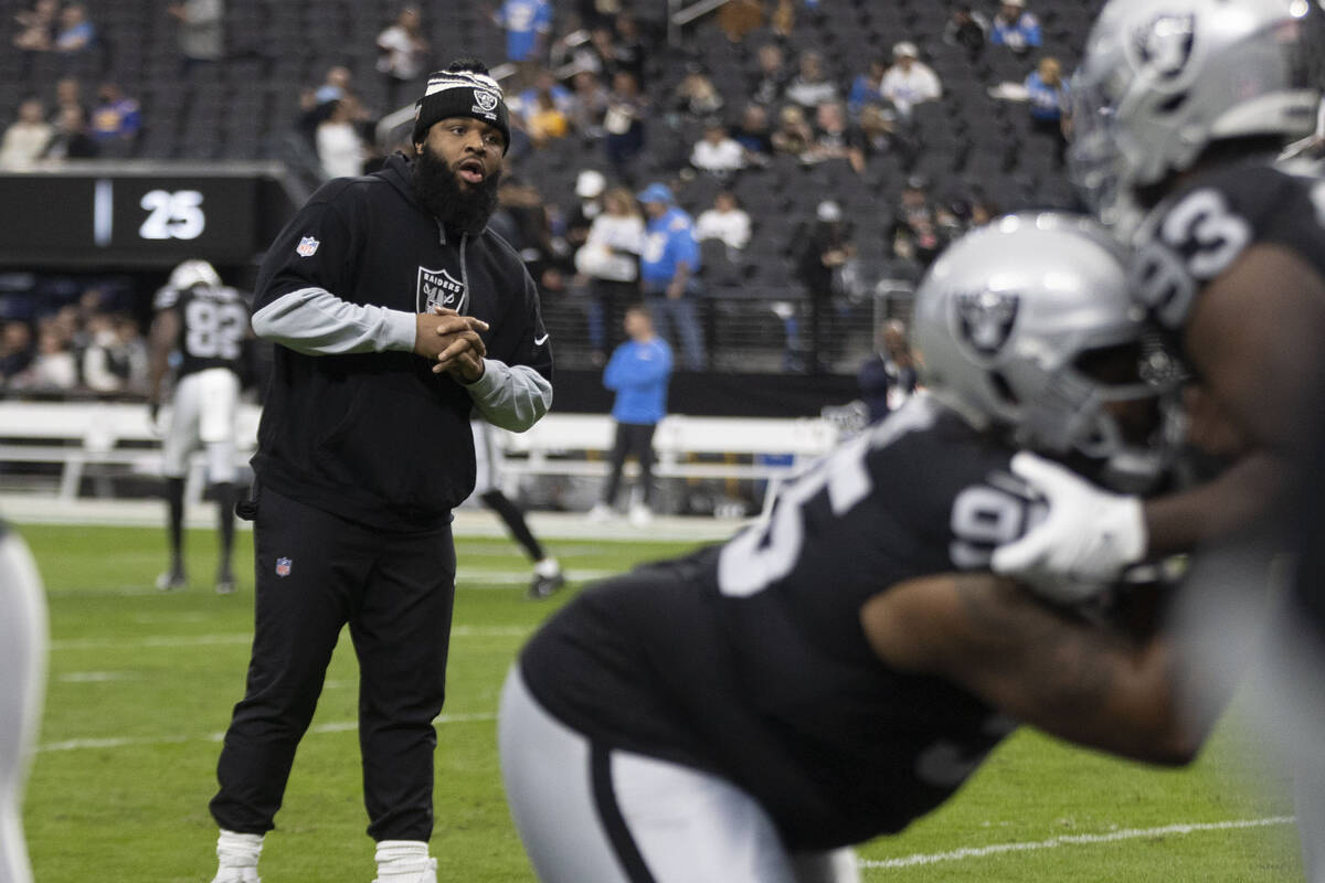 Raiders defensive tackle Christian Wilkins, left, watches the defensive line warm up before an ...