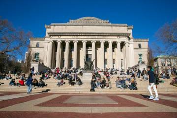 Students sit on the front steps of Low Memorial Library on the Columbia University campus in Ne ...