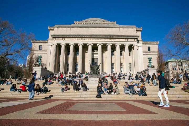 Students sit on the front steps of Low Memorial Library on the Columbia University campus in Ne ...