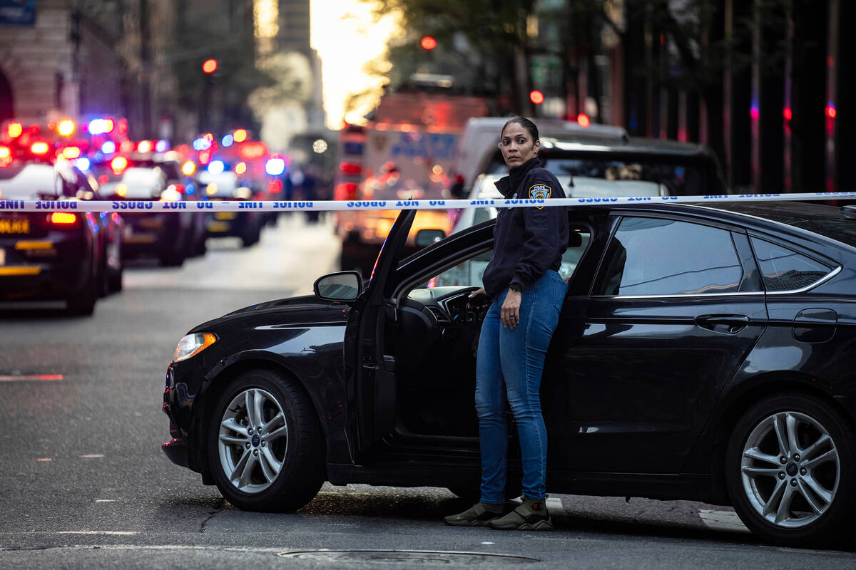 A New York police investigator exits her vehicle at the scene outside a Manhattan office buildi ...