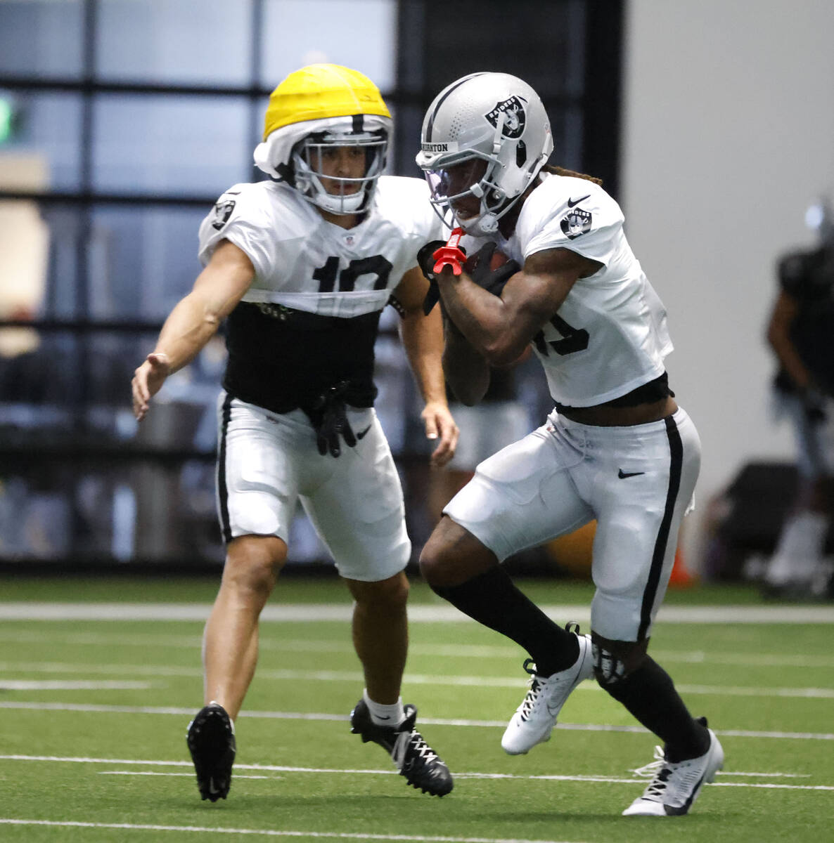 Raiders wide receiver Dont'e Thornton Jr., right, protects thw ball during the team’s trainin ...