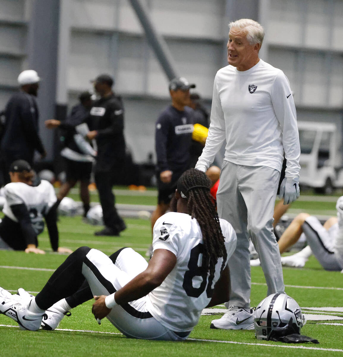 Raiders head coach Pete Carroll chats with tight end Ian Thomas (80) during the team’s t ...