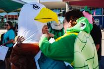 Lynn Lessard, left, gets help putting on an eagle costume during a press conference about the S ...