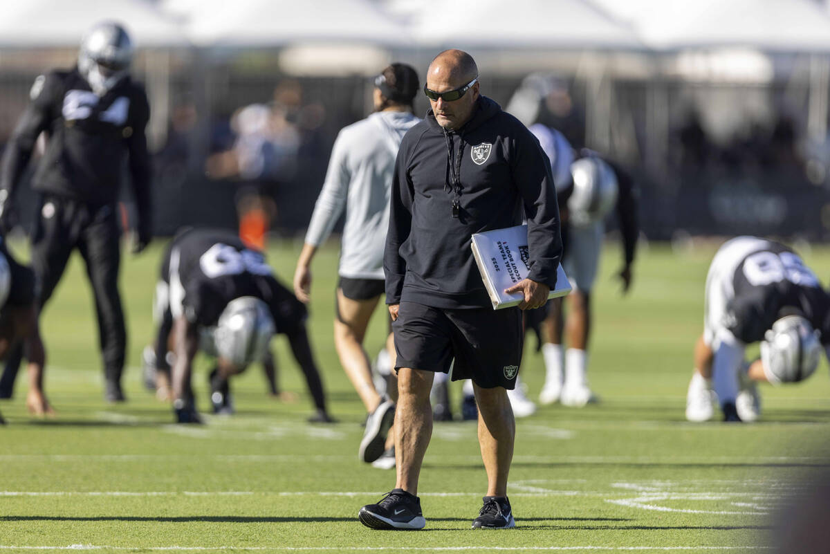 Raiders special teams coordinator Tom McMahon walks the field with his playbook during the team ...
