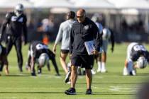 Raiders special teams coordinator Tom McMahon walks the field with his playbook during the team ...