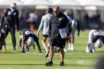 Raiders special teams coordinator Tom McMahon walks the field with his playbook during the team ...