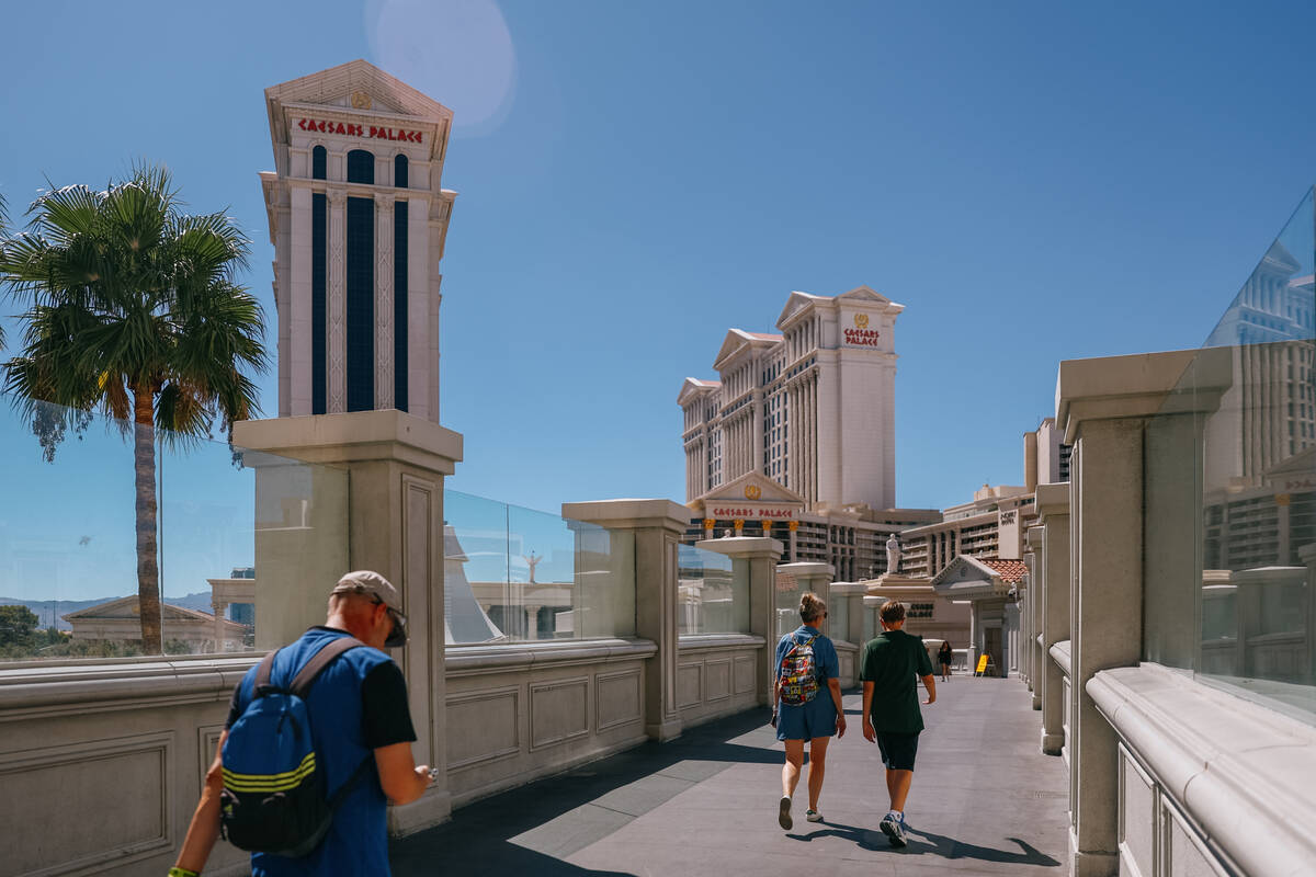 A few people cross a pedestrian bridge leading to Caesar’s Palace on Wednesday, July 30, ...
