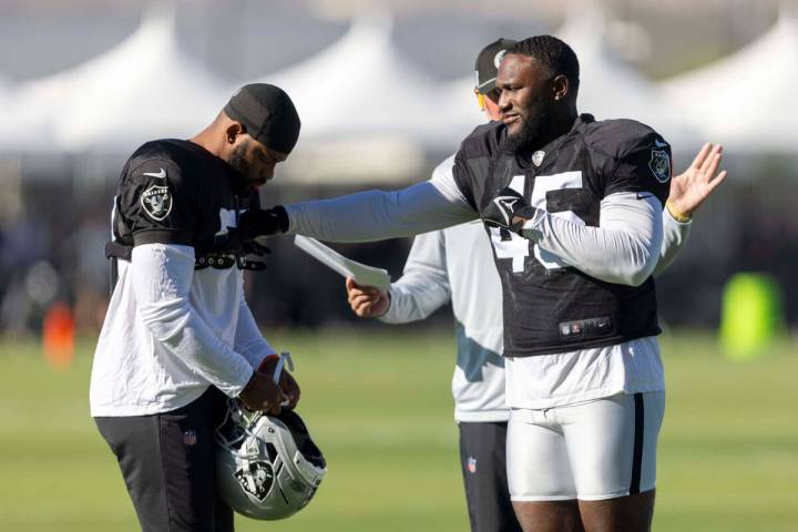 Raiders linebacker Devin White (45) playfully punches linebacker Elandon Roberts (52) during th ...
