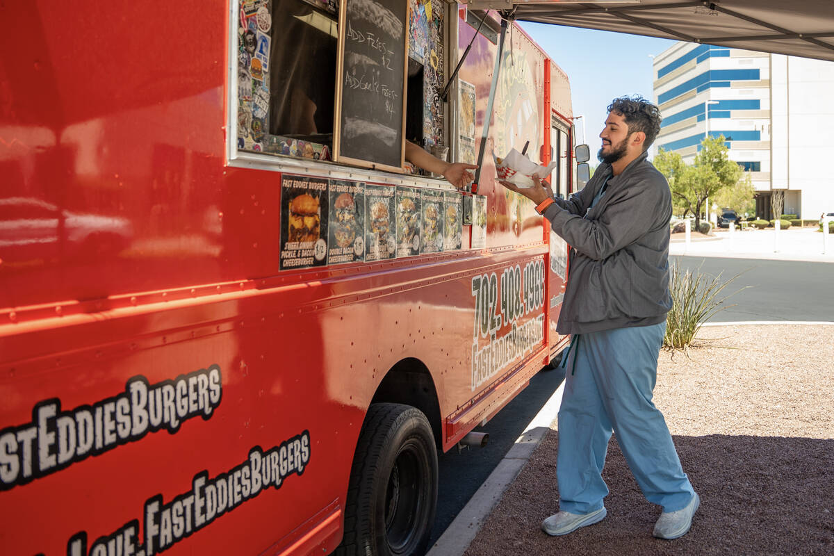 A customer visits Fast Eddie’s Burgers food truck parked in front of MountainView Hospit ...