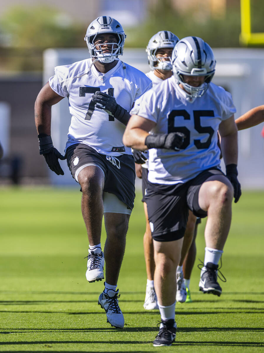 Raiders offensive tackle DJ Glaze (71) follows guard Alex Cappa (65) as they warm up with teamm ...