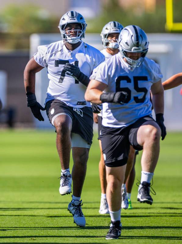 Raiders offensive tackle DJ Glaze (71) follows guard Alex Cappa (65) as they warm up with teamm ...