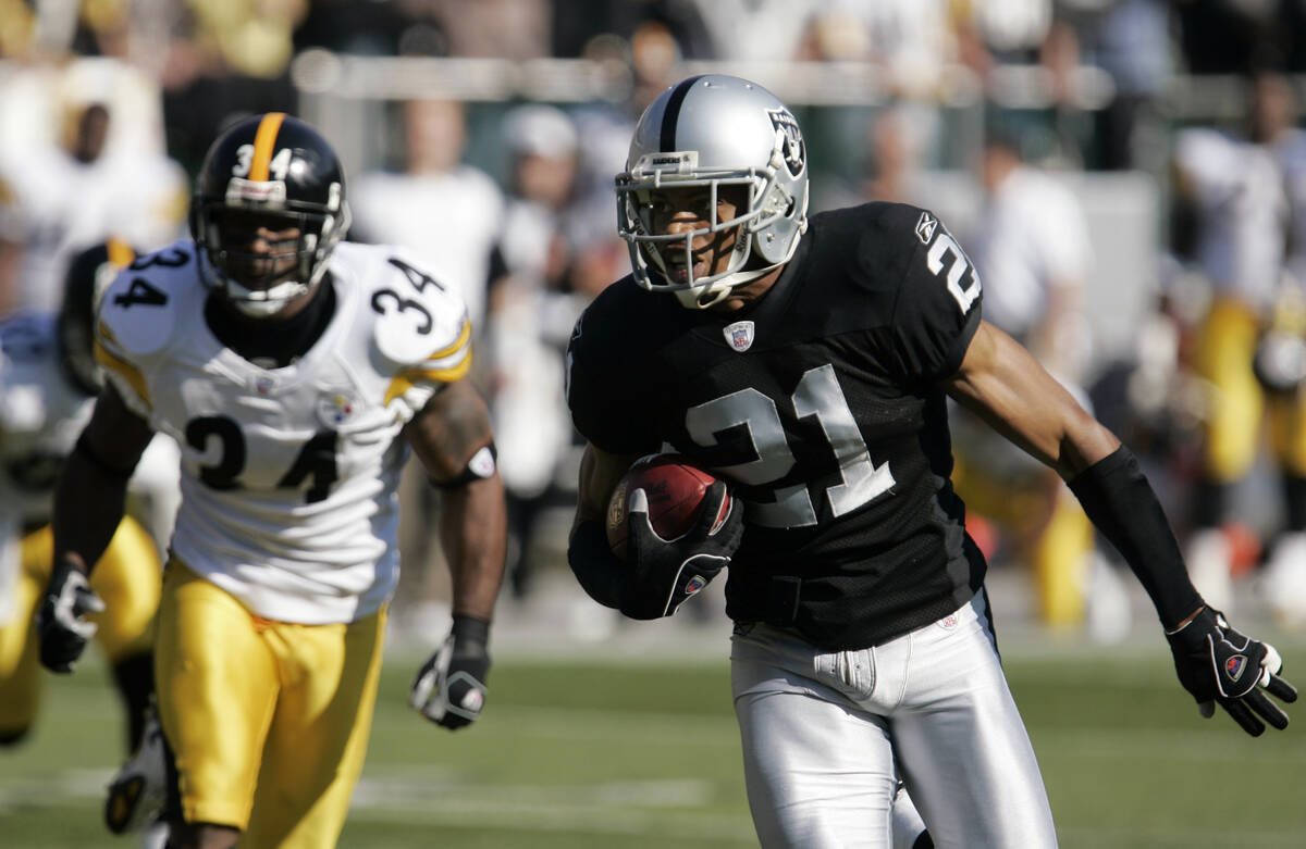 Oakland Raiders cornerback Nnamdi Asomugha, right, scores a touchdown on an interception in fro ...