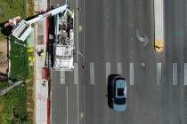 Deon Pace and Jamaine Patton from the City of Las Vegas install a new light and signal pole at ...