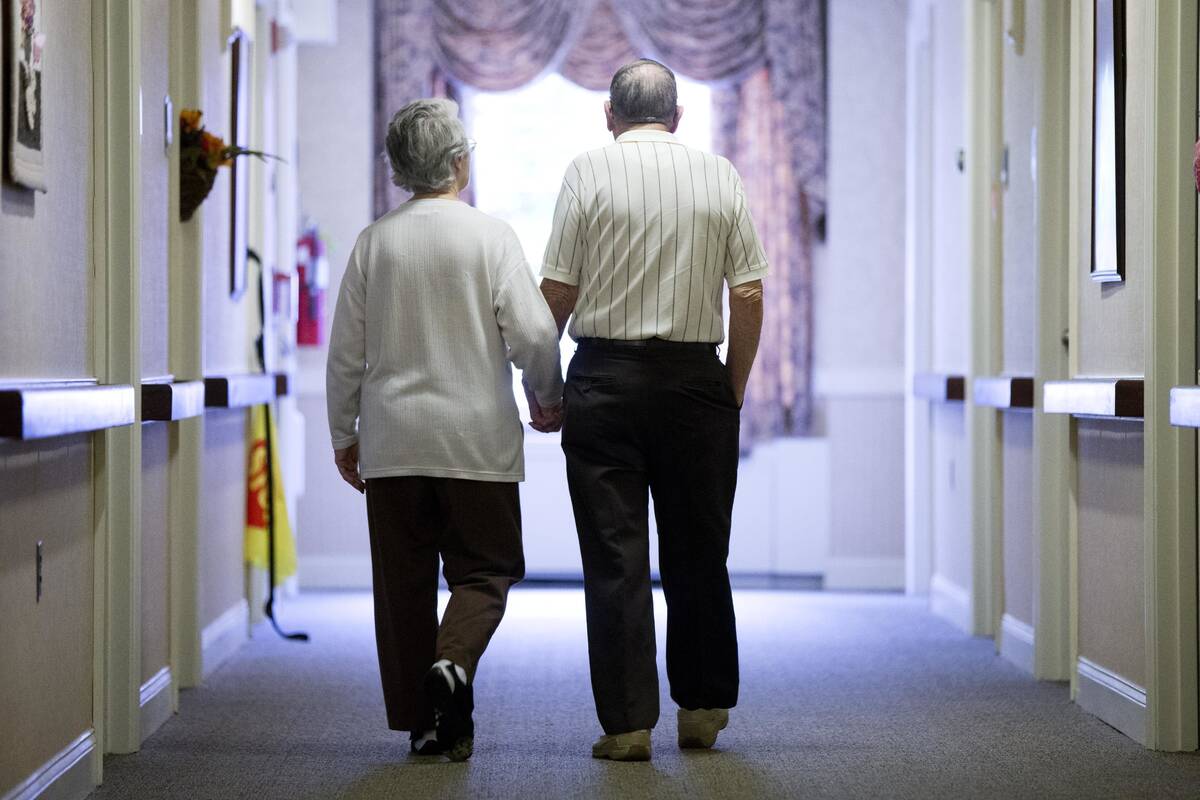 FILE - An elderly couple walks down a hallway in Easton, Pa., on Nov. 6, 2015. (AP Photo/Matt R ...