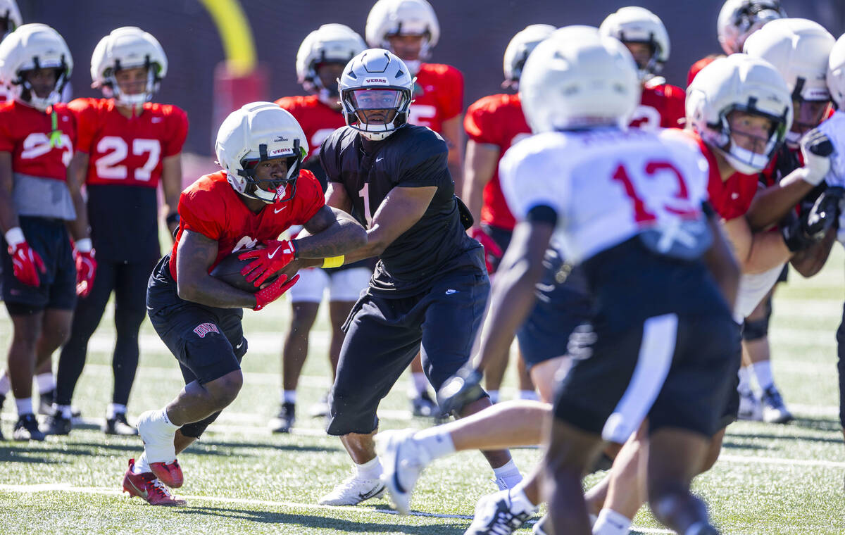 UNLV running back Jai'Den Thomas (9) takes a hand off from quarterback Alex Orji (1) during foo ...