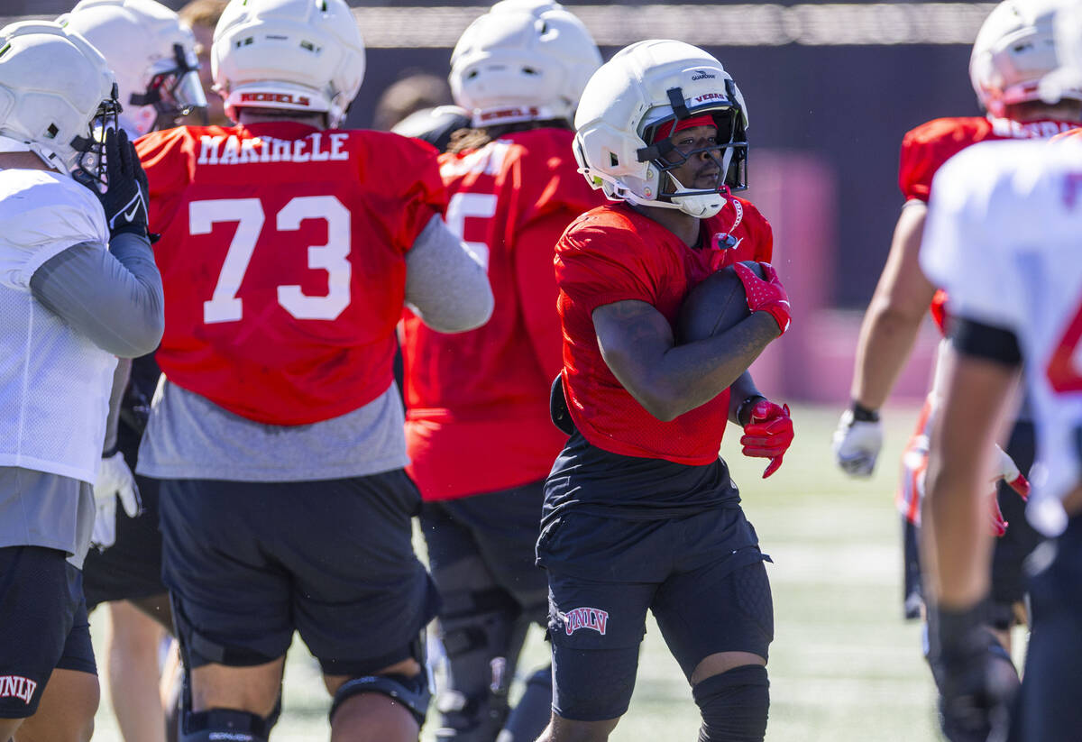 UNLV running back Jai'Den Thomas (9) takes a hand off past the line during football practice at ...