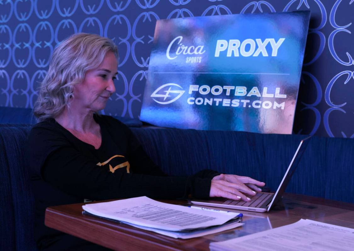 Toni Law, one of owners of Football Contest Proxy, works on her laptop as she waits to meet wit ...