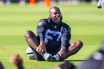 Raiders linebacker Germaine Pratt (57) stretches with teammates as a coach approaches during th ...