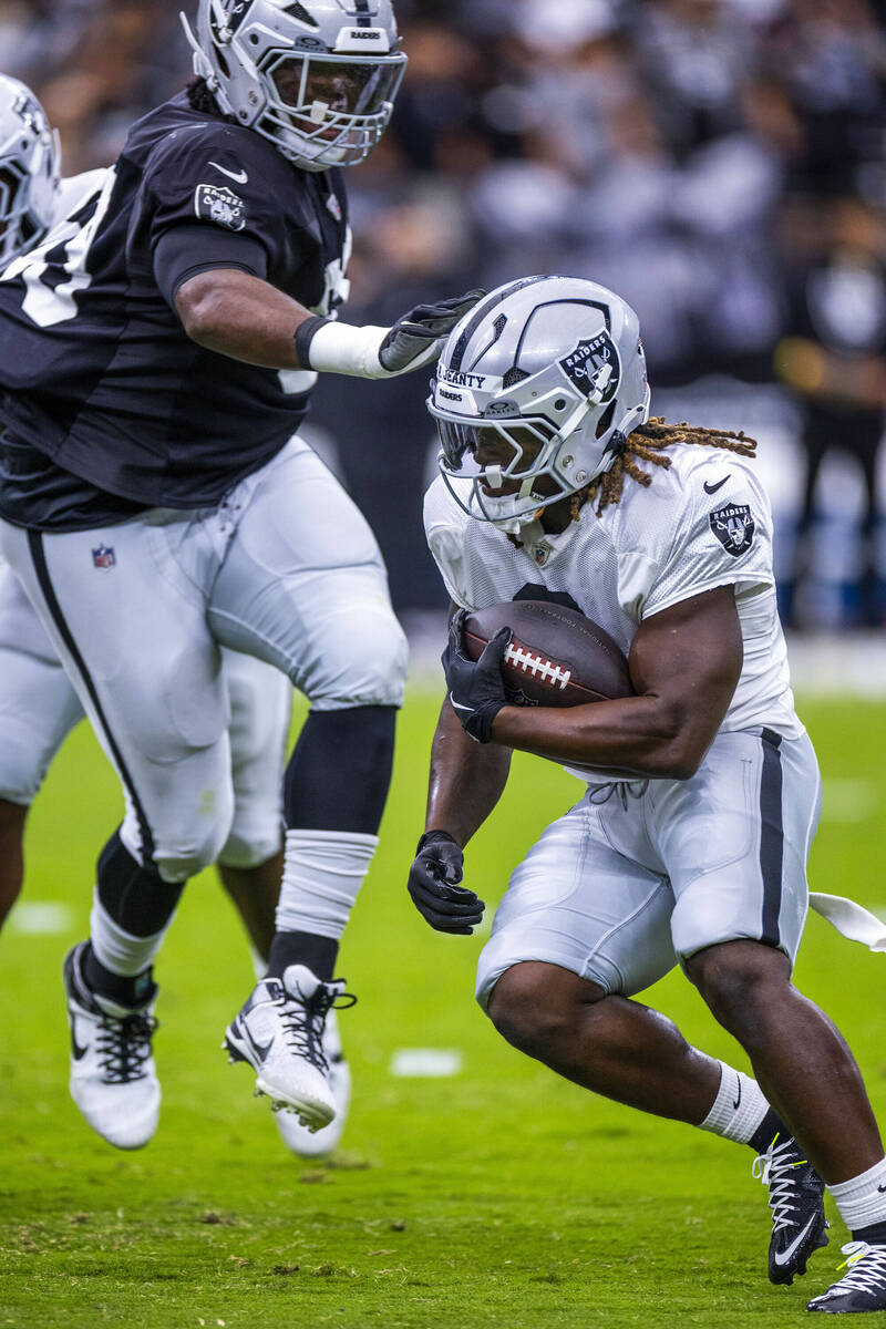 Raiders running back Ashton Jeanty (2) looks to avoid a tackle on a run during the first half o ...