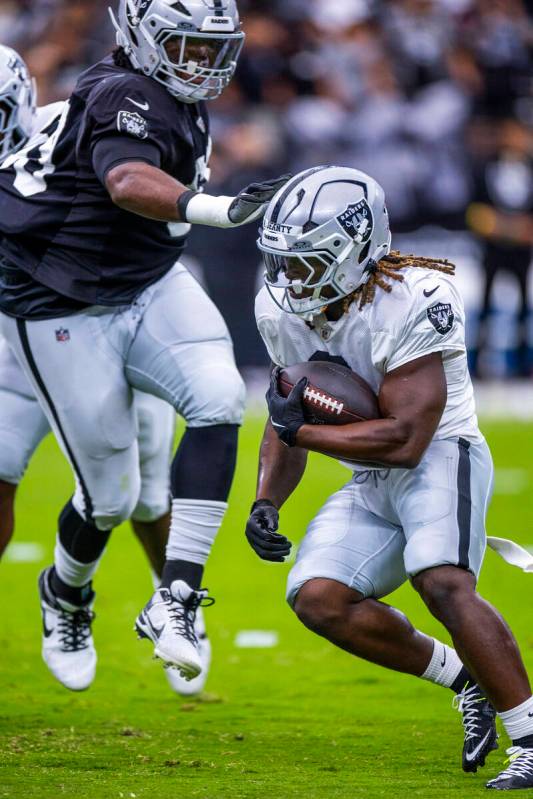 Raiders running back Ashton Jeanty (2) looks to avoid a tackle on a run during the first half o ...