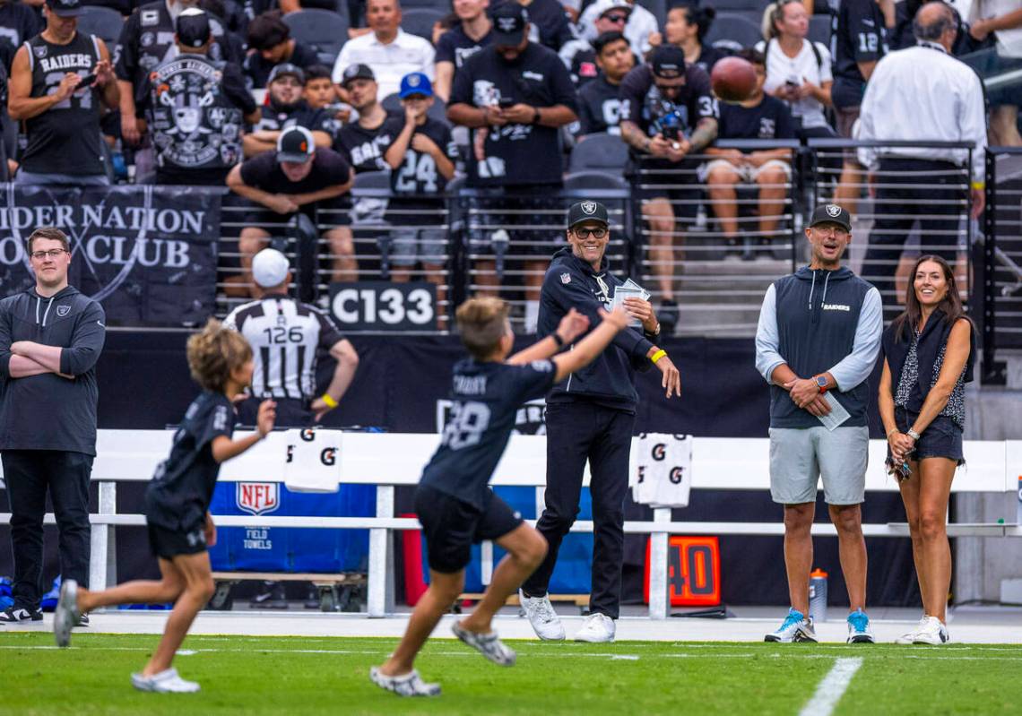 Raiders part owner Tom Brady throws a pass to the children of general manager John Spytek who l ...