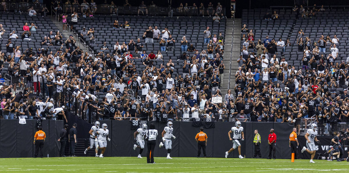 Raiders players take the field during the first half of a Raiders training camp mock game at Al ...