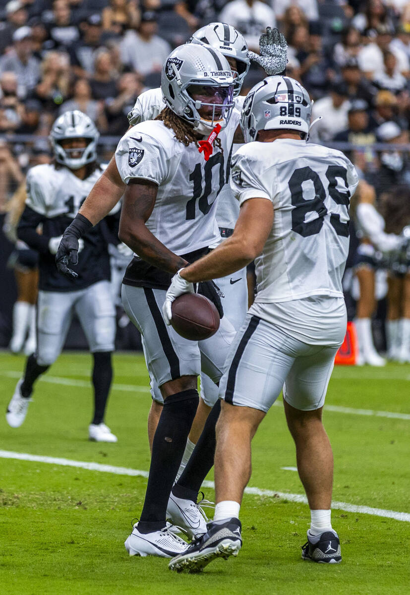 Raiders wide receiver Dont'e Thornton Jr. (10) congratulates tight end Brock Bowers (89) on a t ...