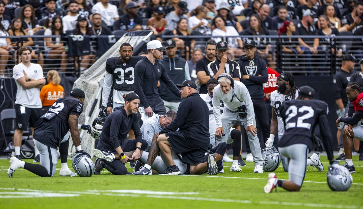 Raiders head coach Pete Carroll joins his team in concern as cornerback Lonnie Johnson Jr. (32) ...