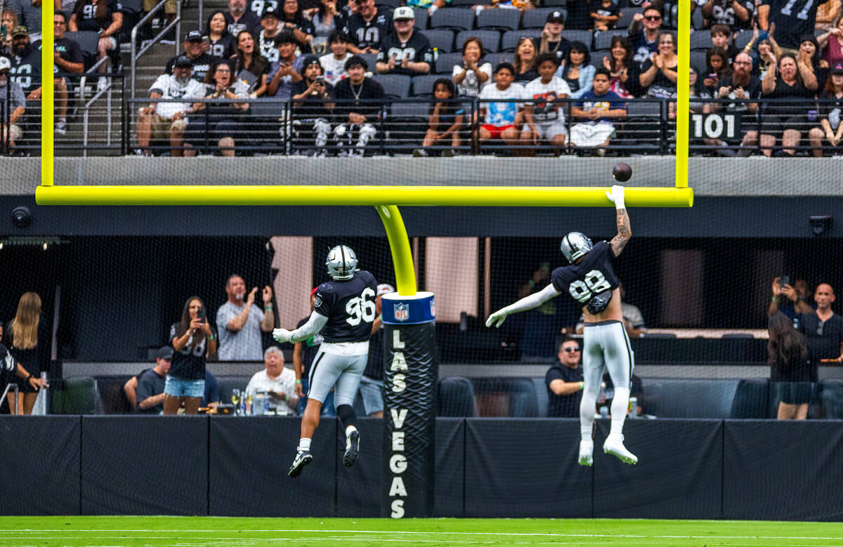 Raiders defensive end Maxx Crosby (98) dunks the ball over the goalpost after a strip and score ...