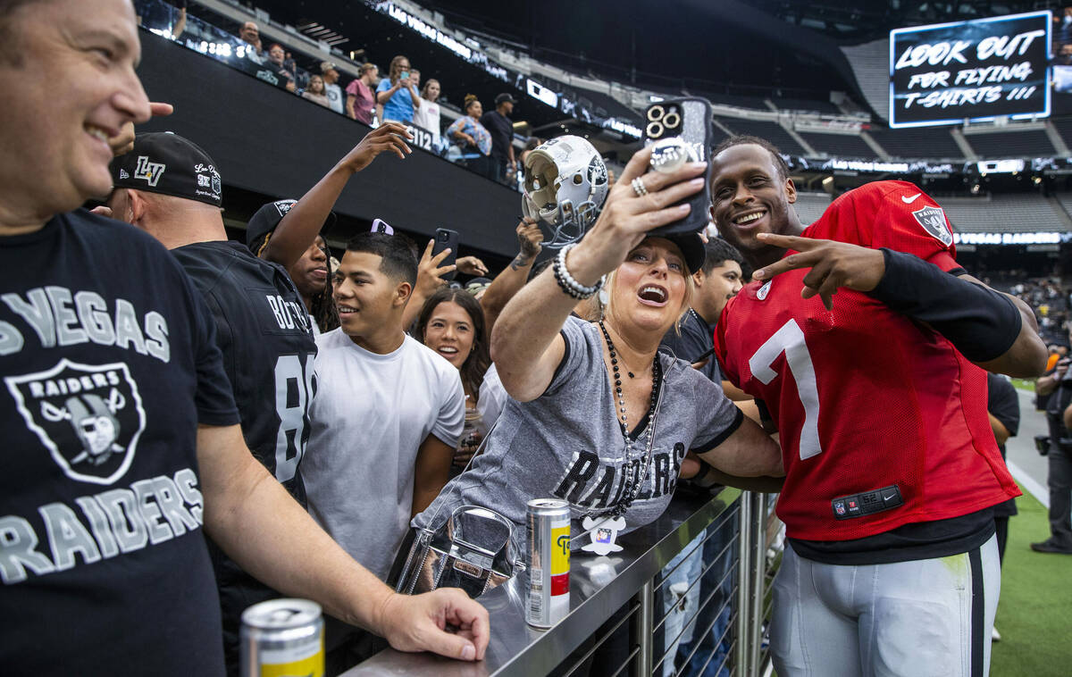 Raiders quarterback Geno Smith (7) takes a photo with a fan while signing autographs following ...