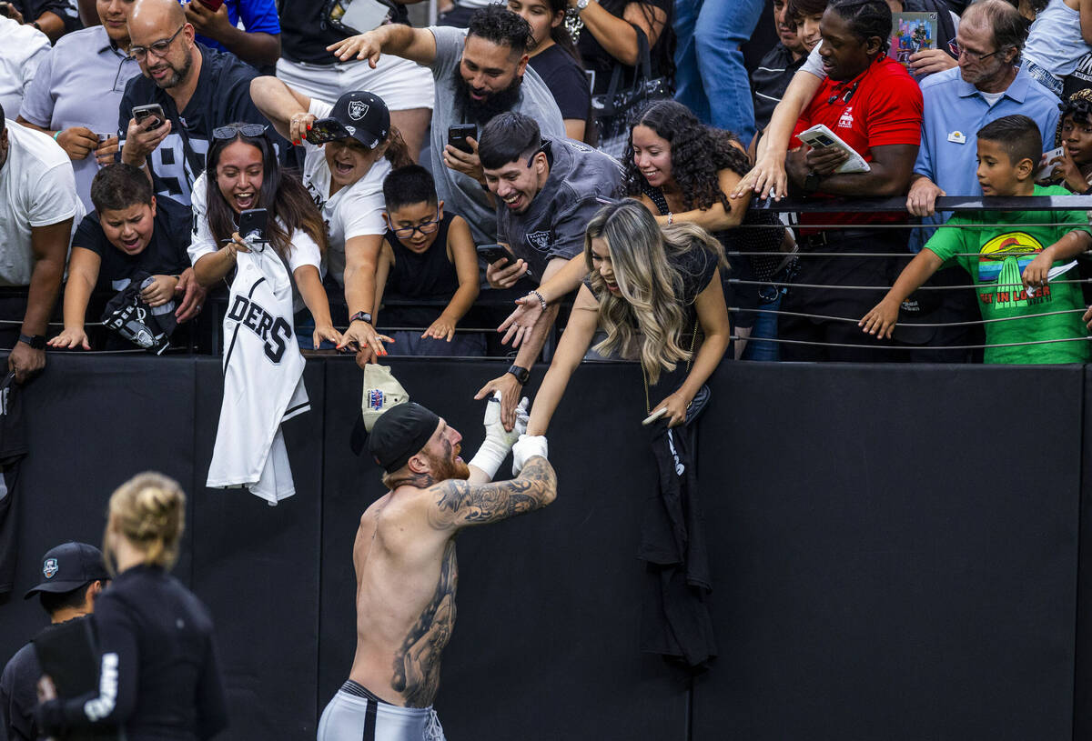 Raiders defensive end Maxx Crosby (98) greets fans following the second half of a Raiders train ...