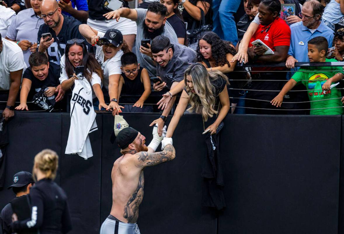Raiders defensive end Maxx Crosby (98) greets fans following the second half of a Raiders train ...