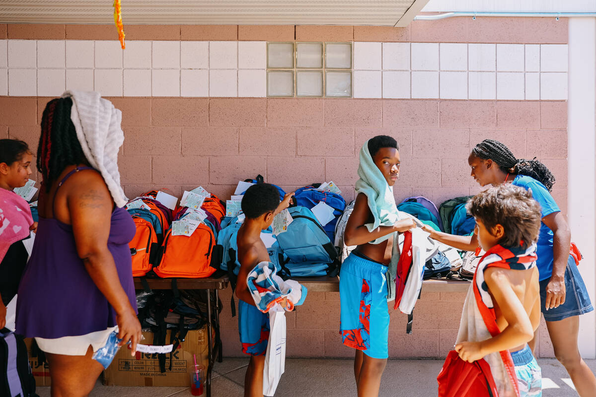 Kids pick up their free backpacks during North Las Vegas’s back-to-school pool party on ...