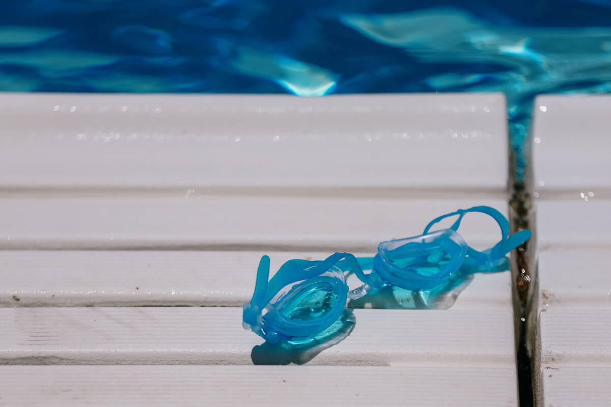 A pair of goggles sit poolside during the City of North Las Vegas’s back-to-school pool ...