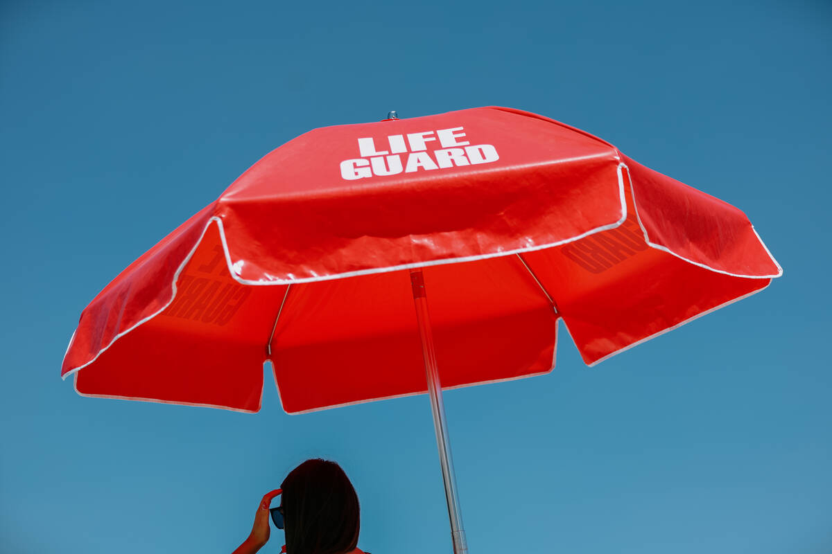 A lifeguard brushes hair out of her face while watching over the pool during the City of North ...