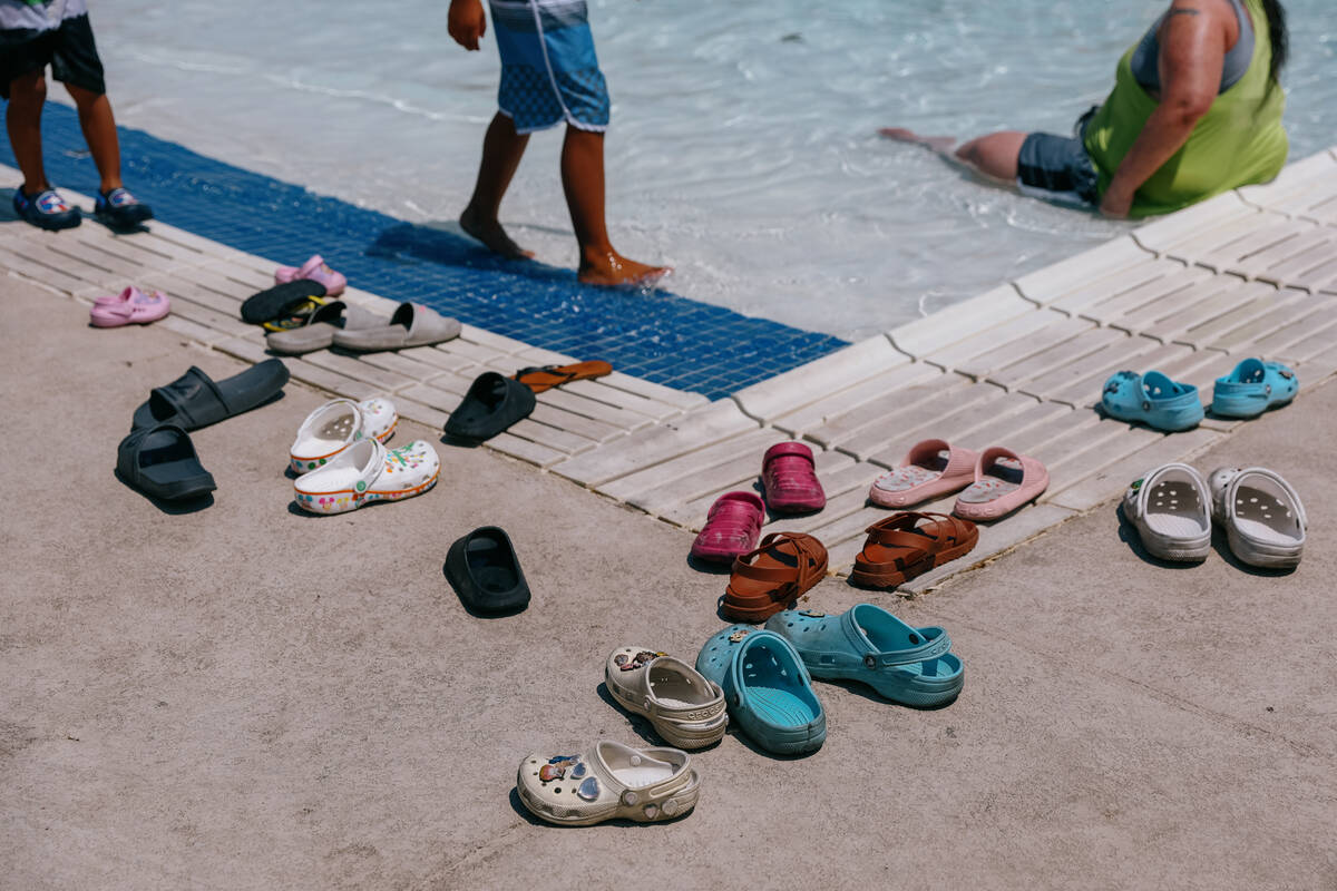 Shoes lie outside the pool as their owners splash around and cool off at the City of North Las ...