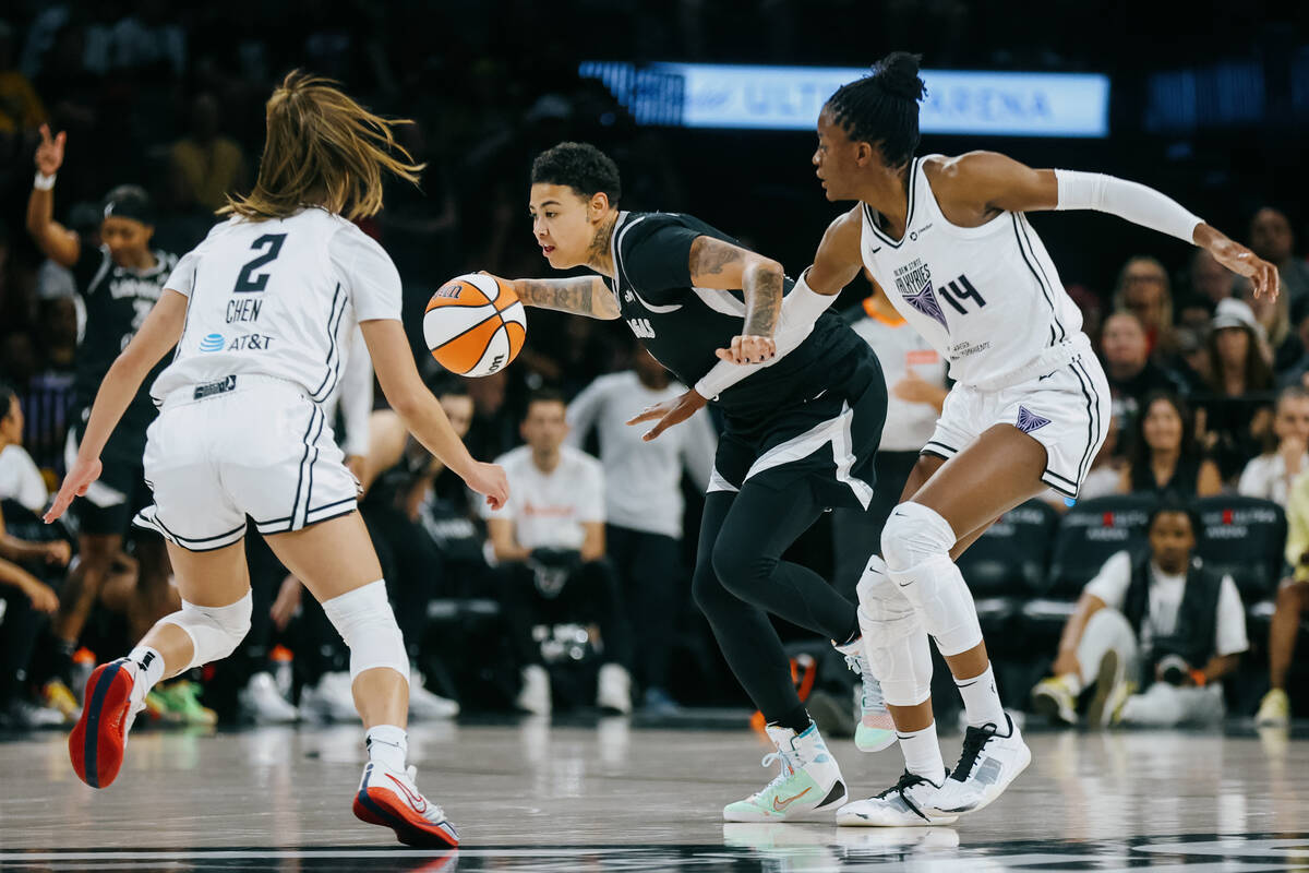 Aces forward Kierstan Bell (1) dribbles the ball as Golden State Valkyries defense closes in du ...